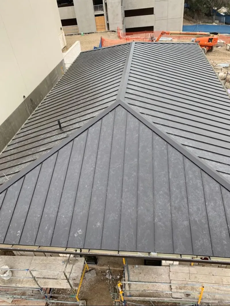 Commercial metal roof construction with crane equipment in Easton